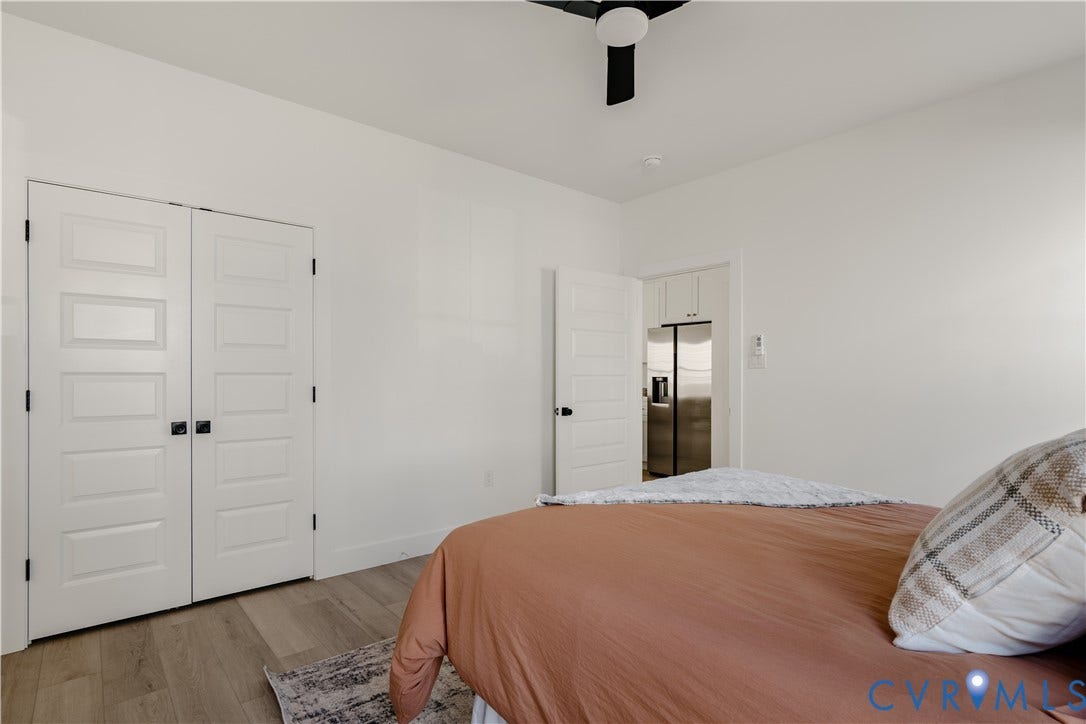 3106 Groveland Avenue, Richmond, VA 23222 White walls with a ceiling fan, plank flooring, and paneled doors with black hardware