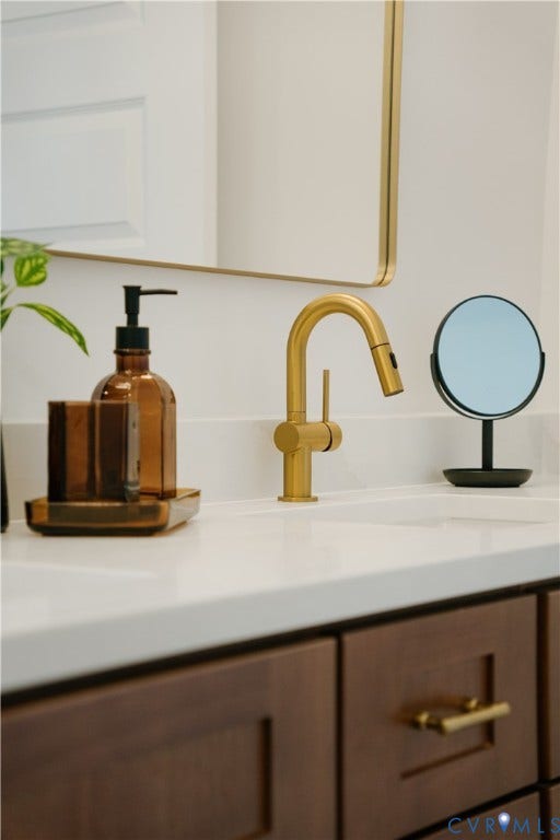 3106 Groveland Avenue, Richmond, VA 23222 White countertop, gold-finish faucet, undermount sink, wood-finish cabinetry, and gold-finish cabinet hardware