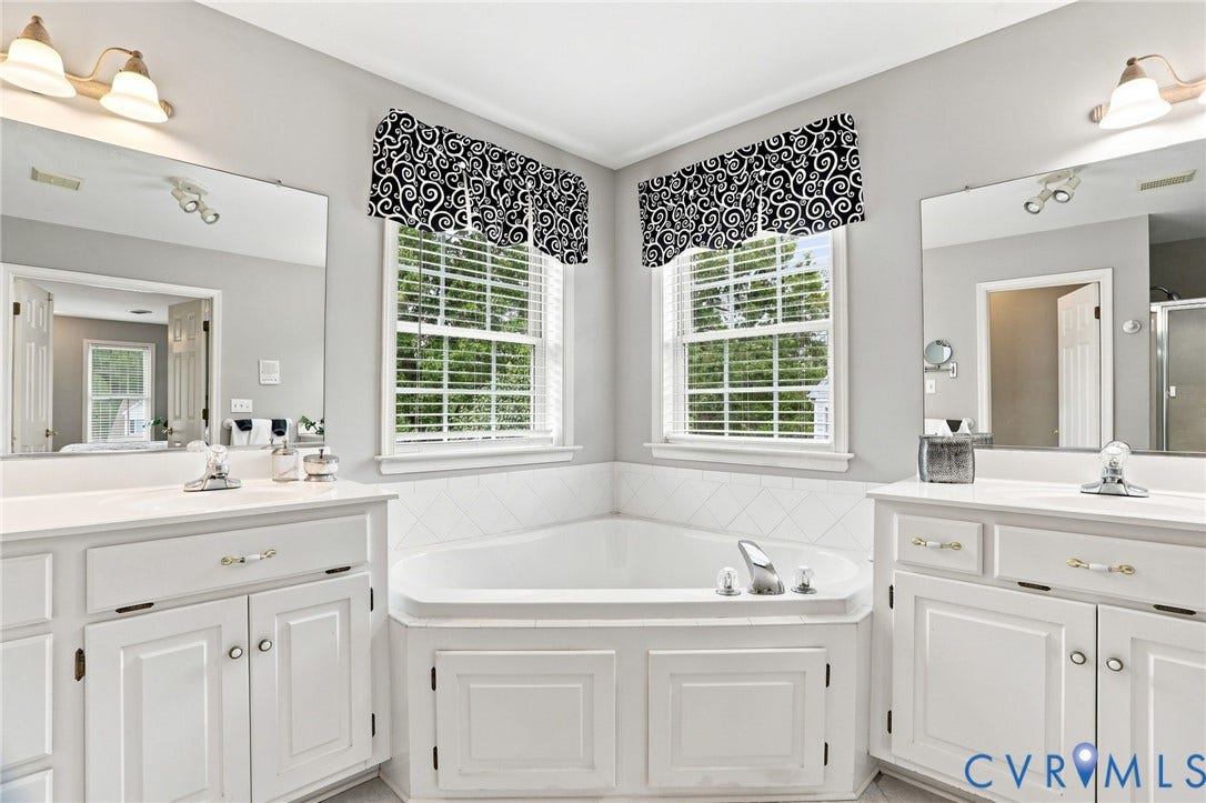 5712 Stephens Point Court, Stephens Point, Chester, VA 23831 Corner soaking tub is framed by two windows and flanked by separate vanities for added functionality.