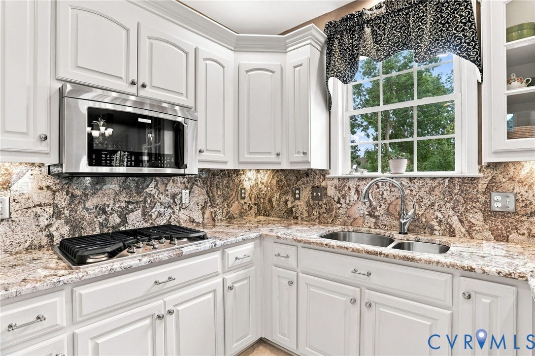 5712 Stephens Point Court, Stephens Point, Chester, VA 23831 Granite countertops and backsplash complement the white cabinetry, stainless steel appliances, and gas cooktop.