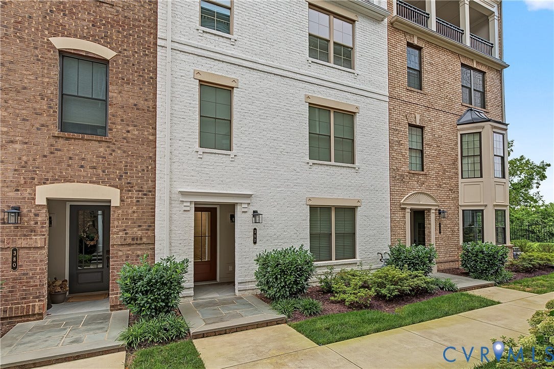 Brick and painted brick exterior with decorative window trim and a bay window feature