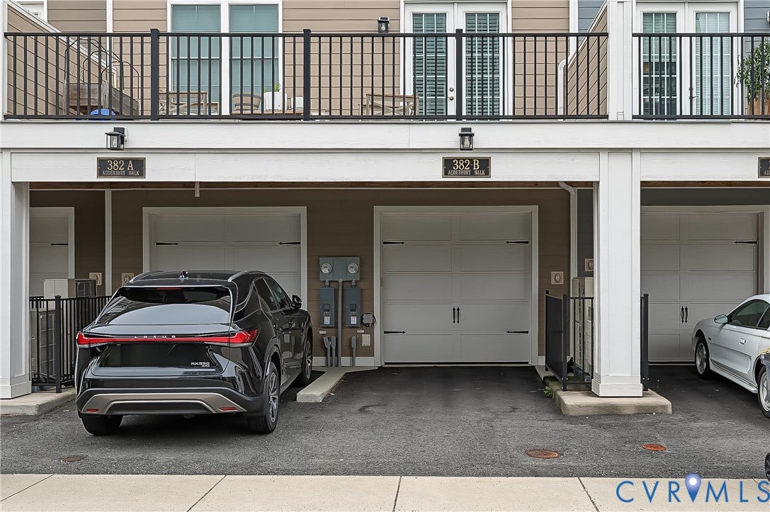 Attached individual garages with white panel doors and black hardware
