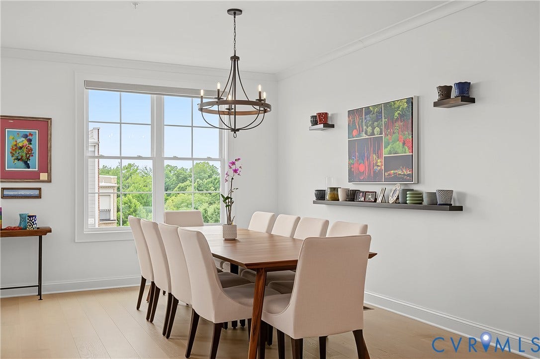 Light wood-finish flooring, crown molding, and a multi-pane window