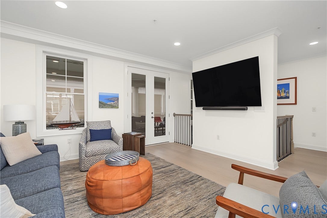 White walls, light wood-finish flooring, recessed lighting, and French doors