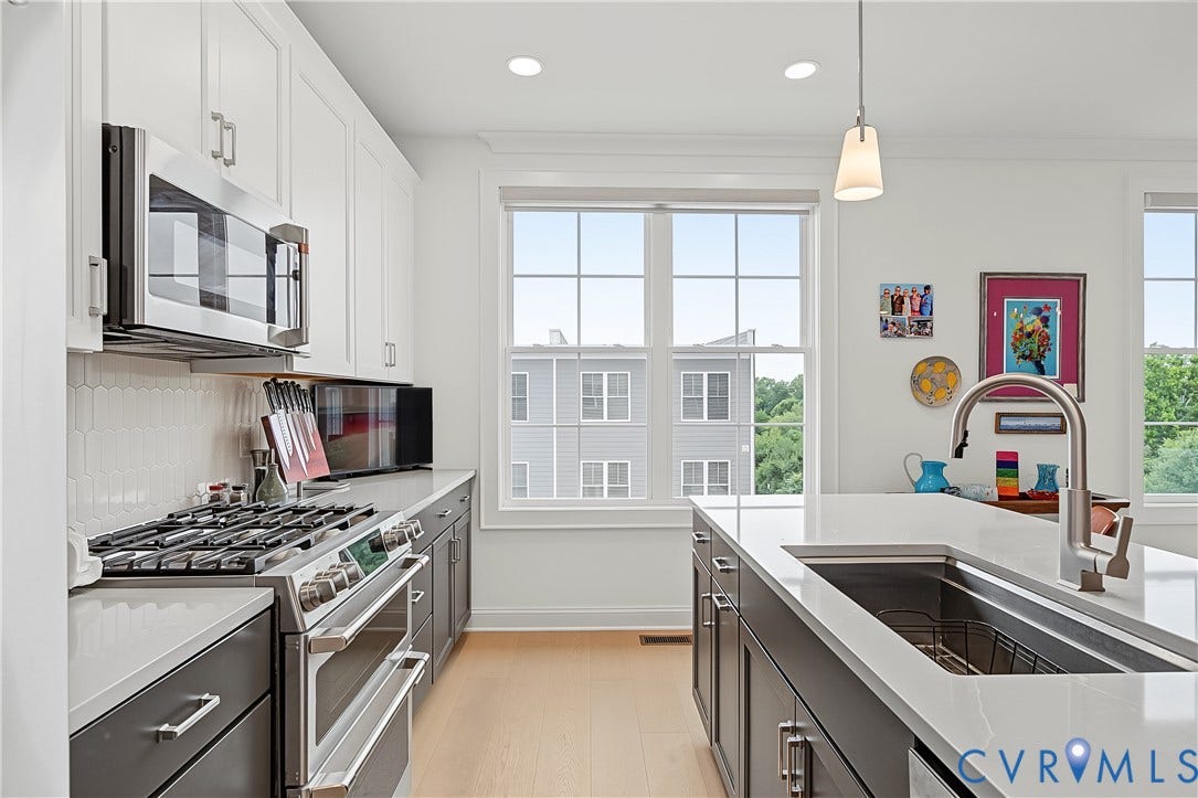 Contemporary kitchen featuring stainless steel appliances, a gas range, a deep undermount sink, and light wood-finish flooring