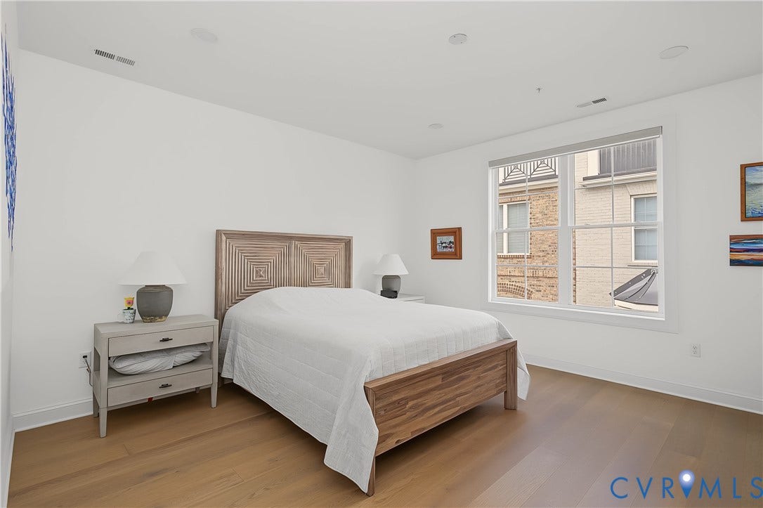 Light wood-finish flooring, recessed lighting, and a large window with white trim