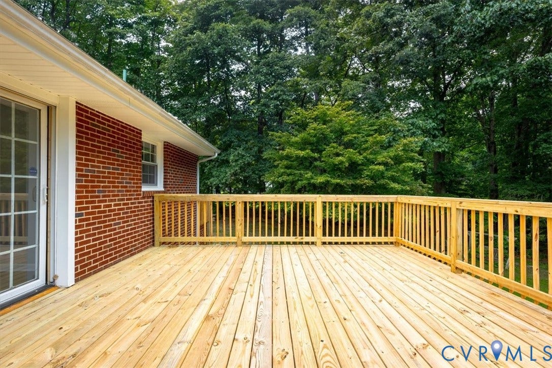 3308 Sylvania Road, Chesterfield, VA 23831 Expansive wood deck with wood railing, red brick exterior, white sliding glass door, and white window trim