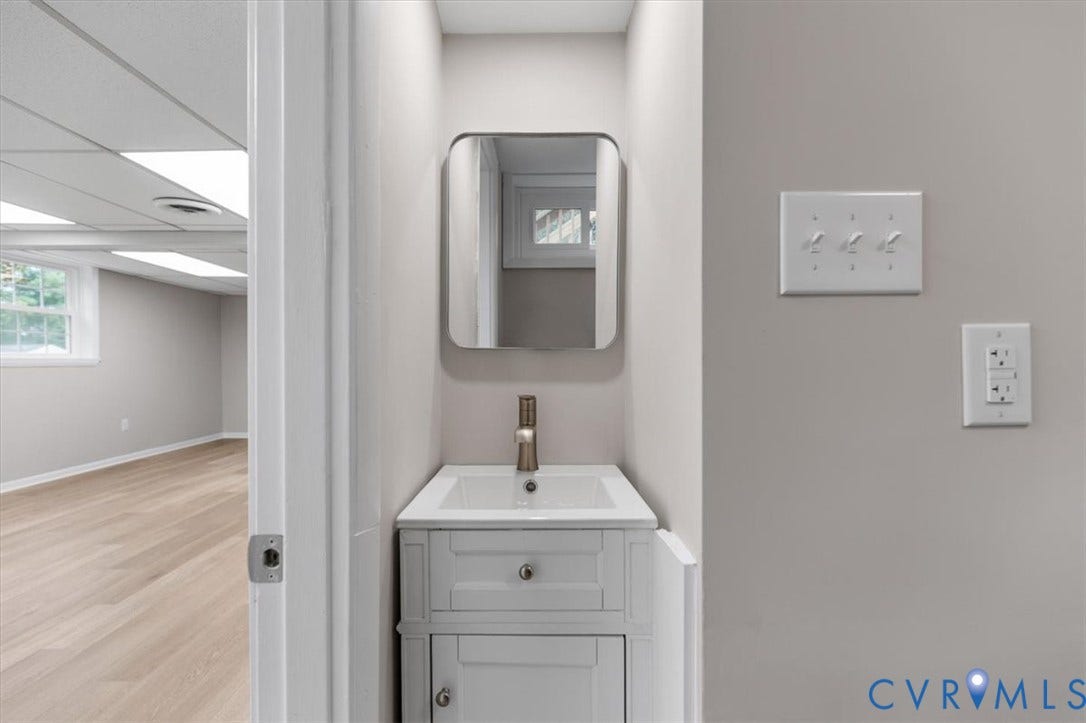 3308 Sylvania Road, Chesterfield, VA 23831 White vanity with an integrated sink and brushed nickel faucet, paired with a rounded rectangular mirror