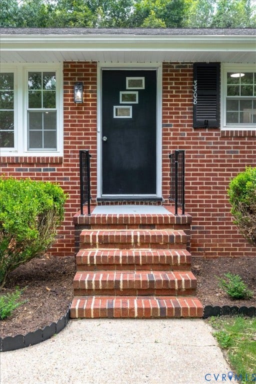 3308 Sylvania Road, Chesterfield, VA 23831 Brick exterior featuring white-framed windows, a black entry door with decorative glass inserts, and brick steps with black metal handrails