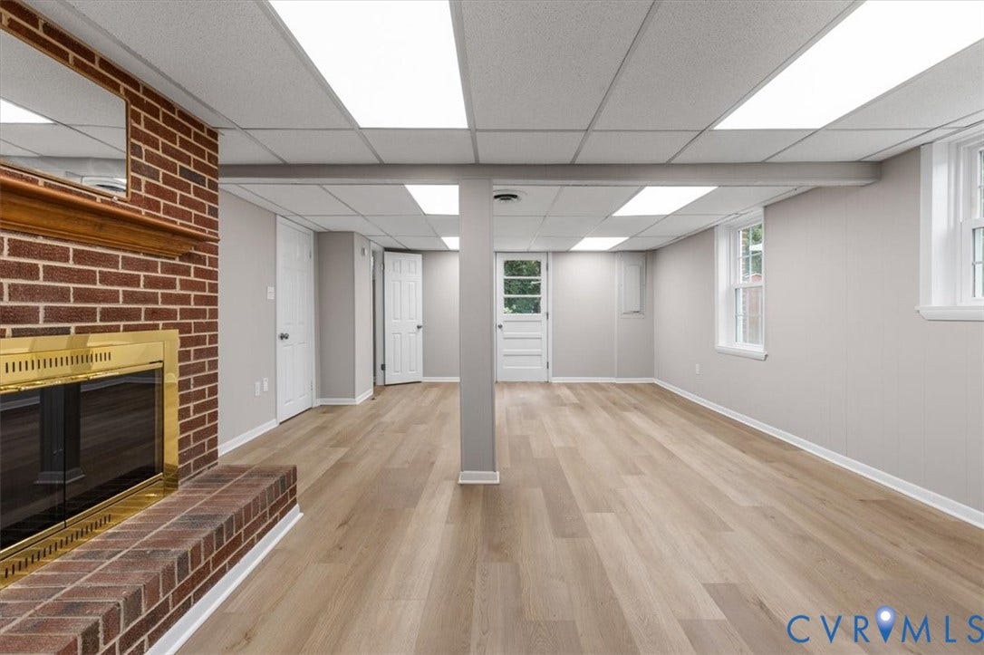 3308 Sylvania Road, Chesterfield, VA 23831 Brick fireplace with a brass-finish insert, wood-finish flooring, drop ceiling with integrated lighting, and multiple windows