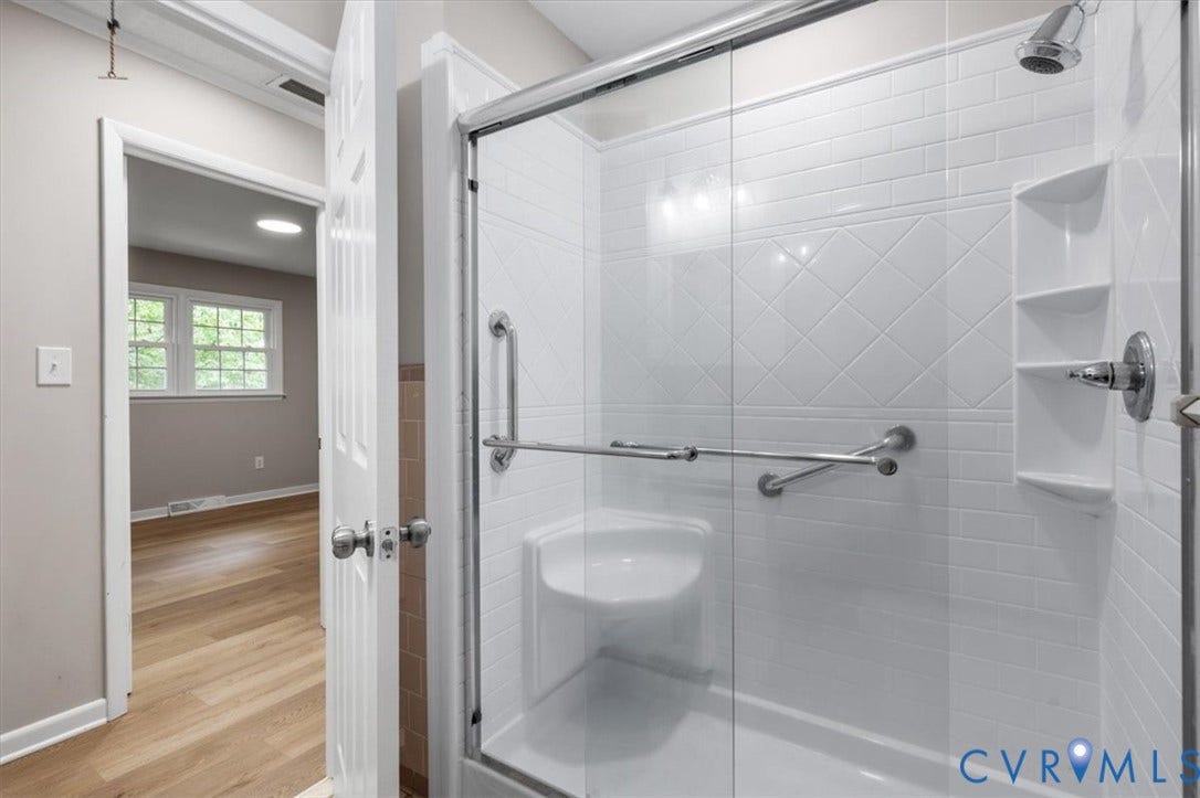 3308 Sylvania Road, Chesterfield, VA 23831 Glass-enclosed shower with a built-in seat, grab bars, and integrated shelving