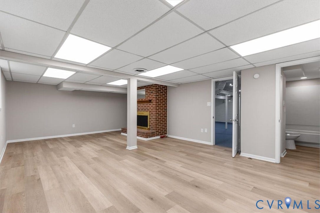 3308 Sylvania Road, Chesterfield, VA 23831 Spacious room featuring wood-finish flooring, a brick fireplace with a mantel, and a drop ceiling with recessed lighting