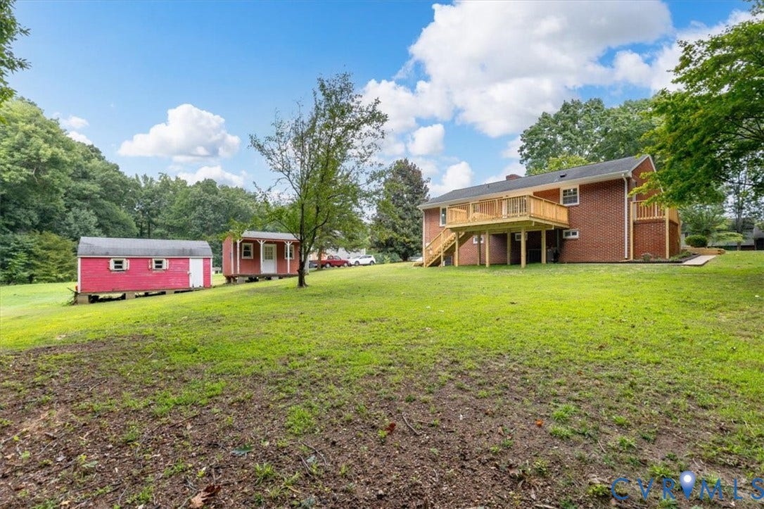 3308 Sylvania Road, Chesterfield, VA 23831 Expansive green lawn with a red brick exterior, a multi-level wooden deck, and two red storage structures