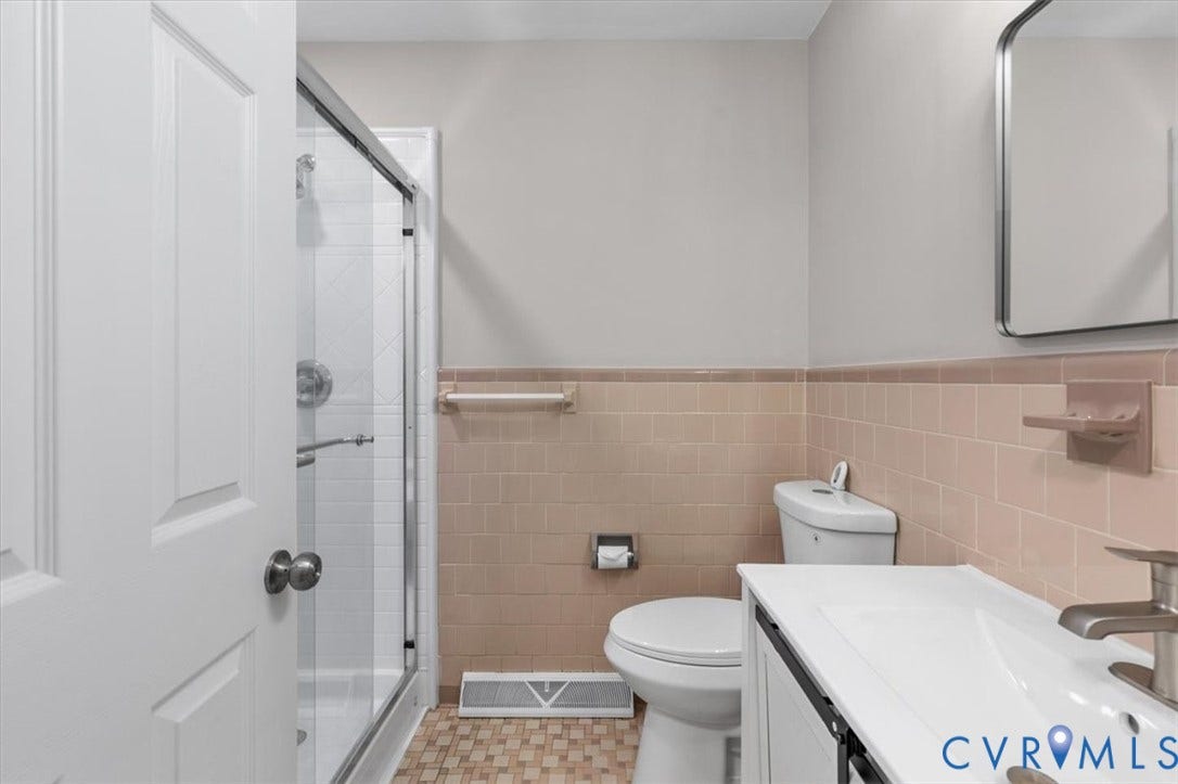 3308 Sylvania Road, Chesterfield, VA 23831 Bathroom featuring a glass-enclosed shower, built-in toilet, vanity with integrated sink, and wall-mounted mirror