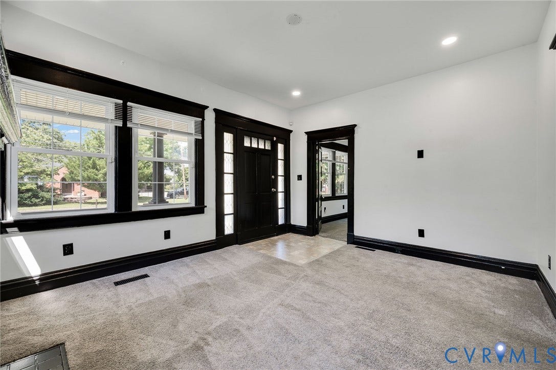 Entryway featuring a dark wood-finish door with sidelights, contrasting dark trim, recessed lighting, and soft gray carpeting