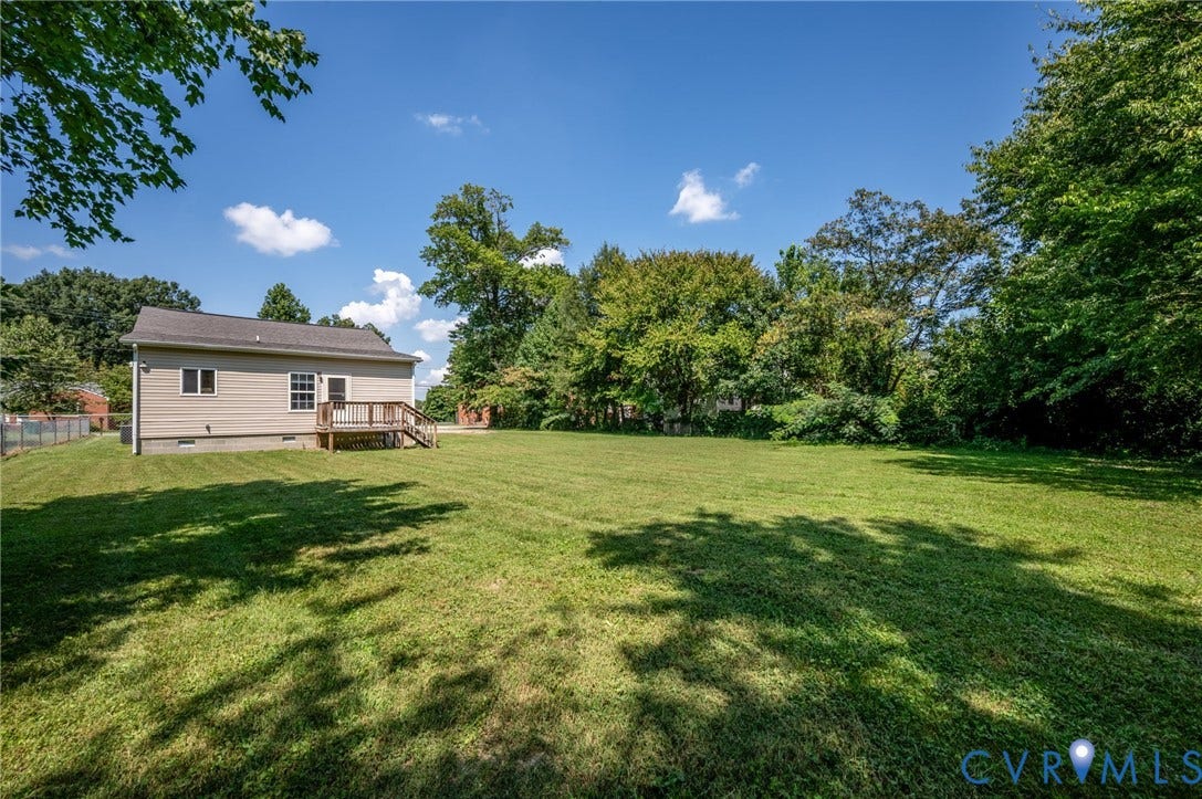 Expansive manicured lawn with mature shade trees and open grounds