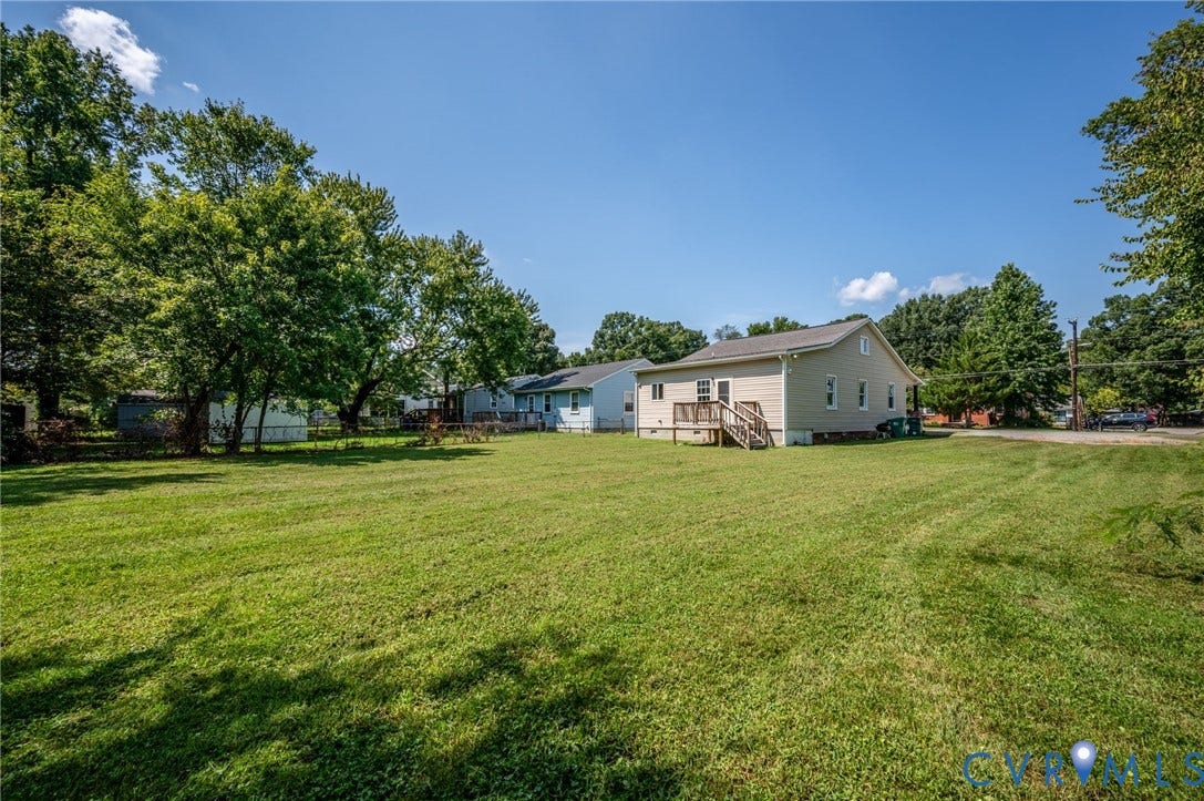 Expansive grassy yard with mature trees