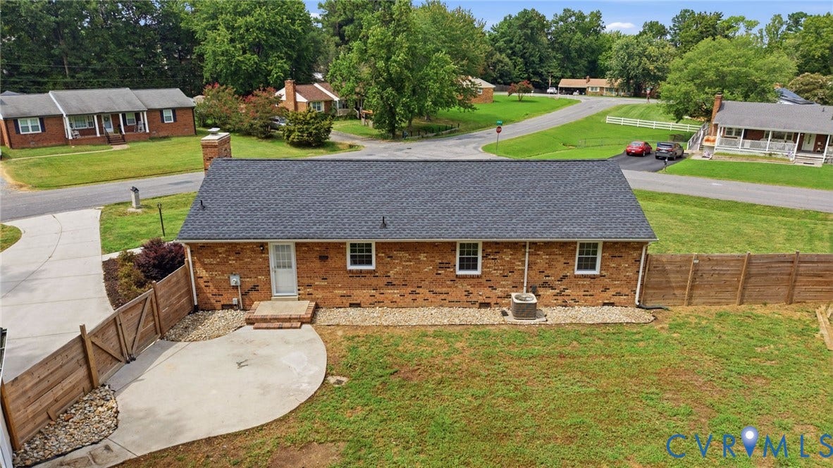 3221 Clintwood Road, Midlothian, VA 23112 Brick exterior with a dark shingle roof, featuring a private fenced yard and a curved concrete patio