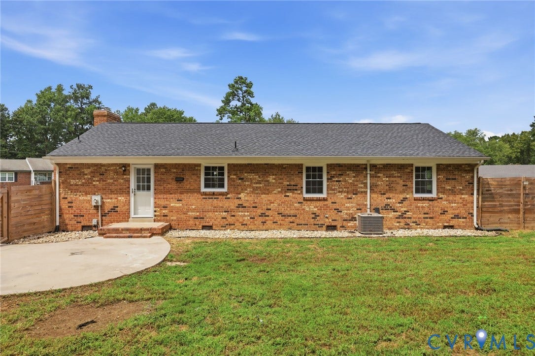 3221 Clintwood Road, Midlothian, VA 23112 Brick exterior with a dark shingled roof, featuring multiple windows, a rear entry door, and a concrete patio