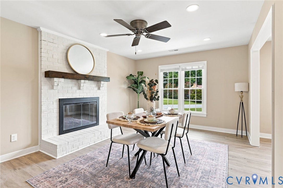 3221 Clintwood Road, Midlothian, VA 23112 White brick fireplace with dark wood mantel, wood-finish flooring, ceiling fan, recessed lighting, and a large window
