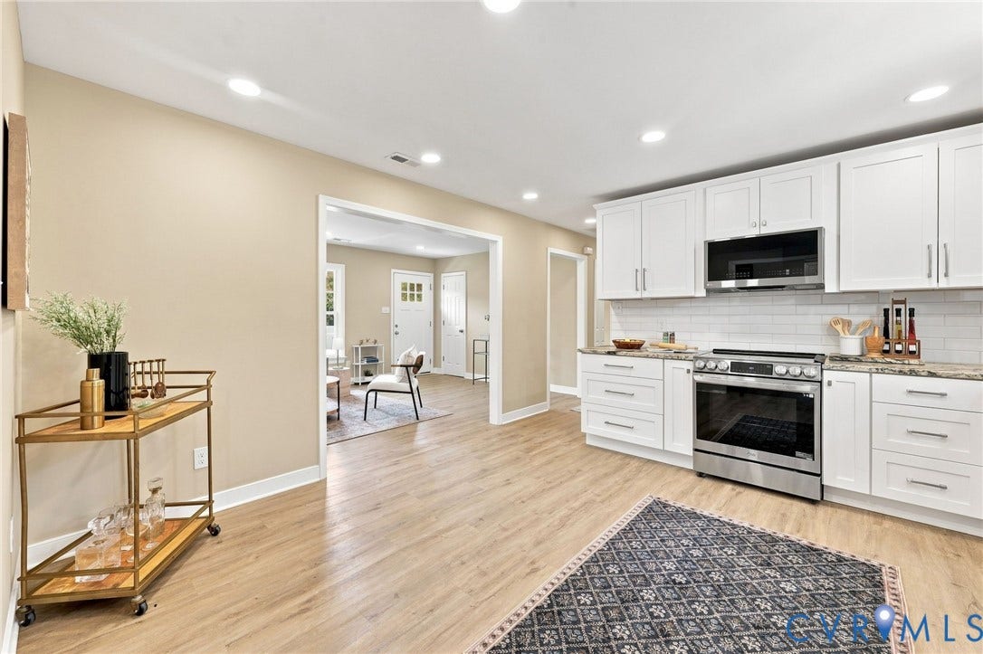 3221 Clintwood Road, Midlothian, VA 23112 Recessed lighting illuminates the kitchen featuring white cabinetry, a stainless steel oven with an overhead microwave, and a subway tile backsplash