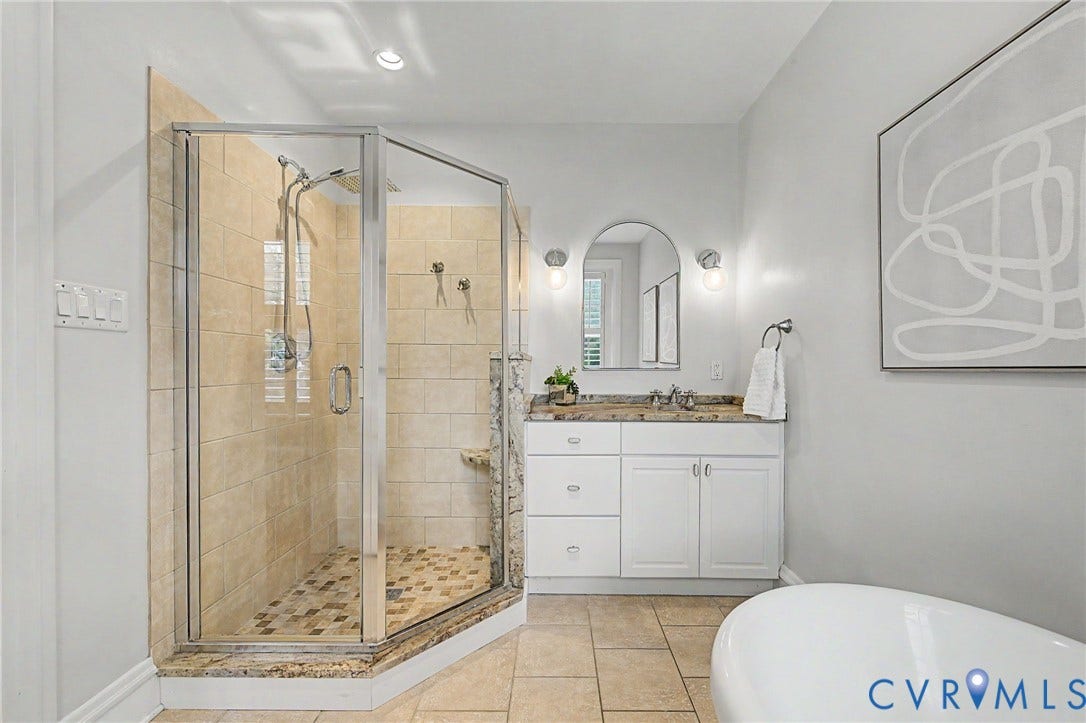 Glass-enclosed shower with a tiled interior and mosaic flooring