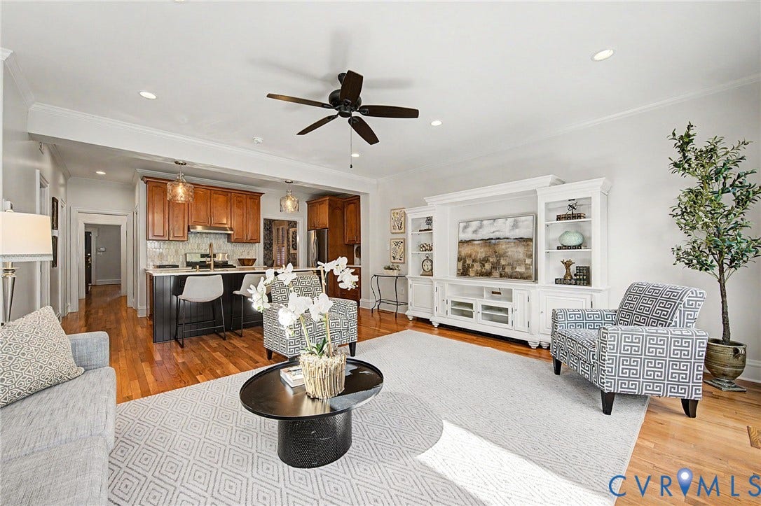 Hardwood flooring and recessed lighting throughout, complemented by a kitchen island with pendant lighting, a ceiling fan, and crown molding