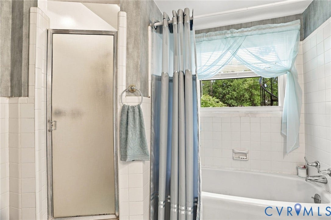 4512 Forrestal Road, Chester, VA 23831 Bathtub with white tile surround, frosted glass shower enclosure, and single window