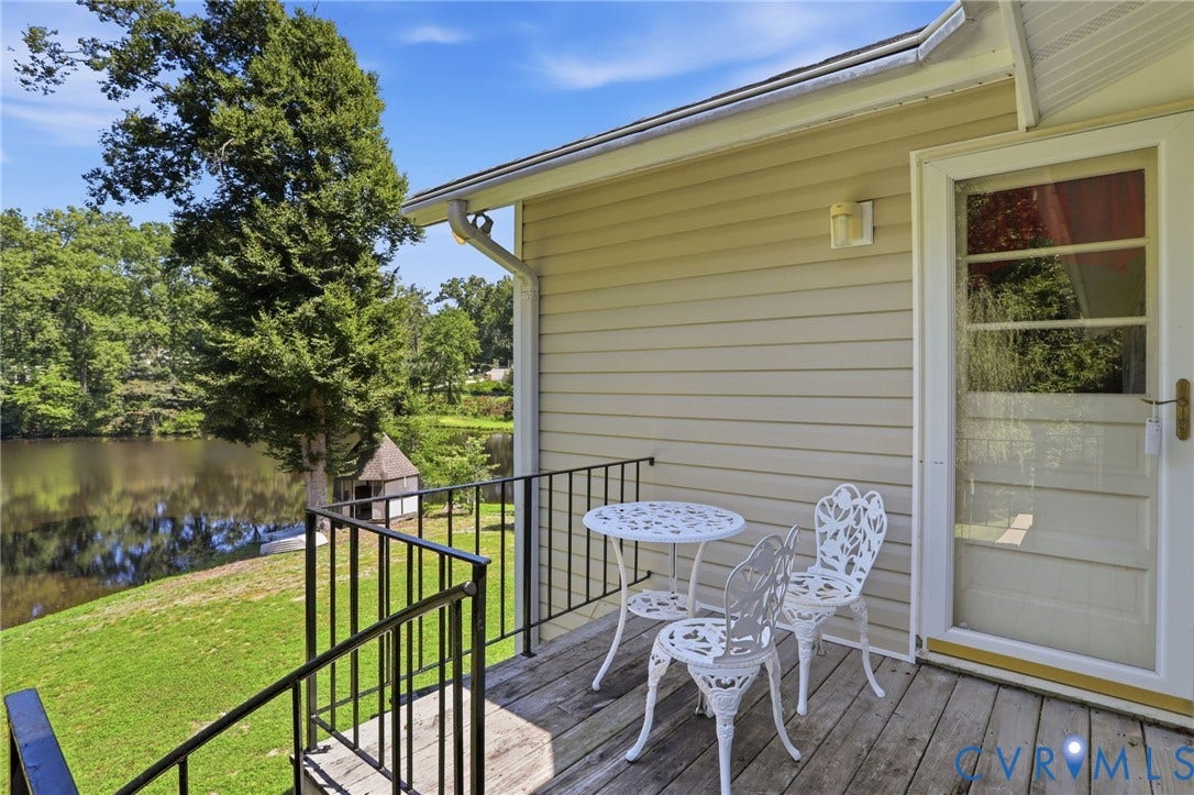 4512 Forrestal Road, Chester, VA 23831 Outdoor wood-finish deck with black metal railings, leading to a body of water