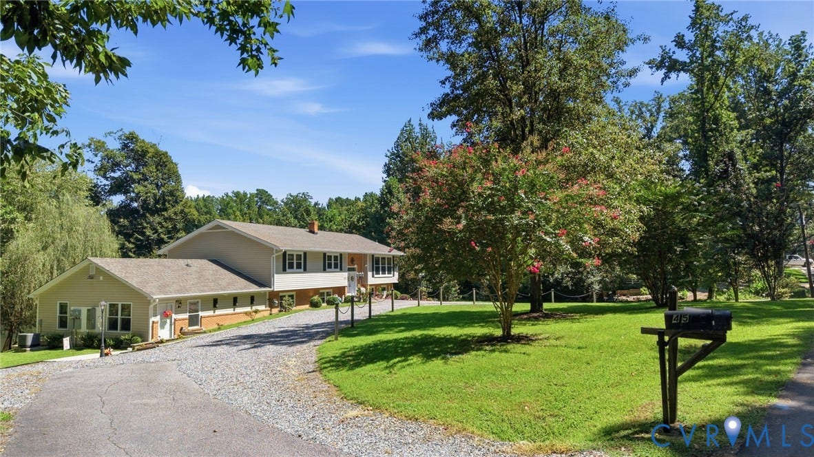 4512 Forrestal Road, Chester, VA 23831 Split-level residence featuring a gravel driveway and a mature tree canopy