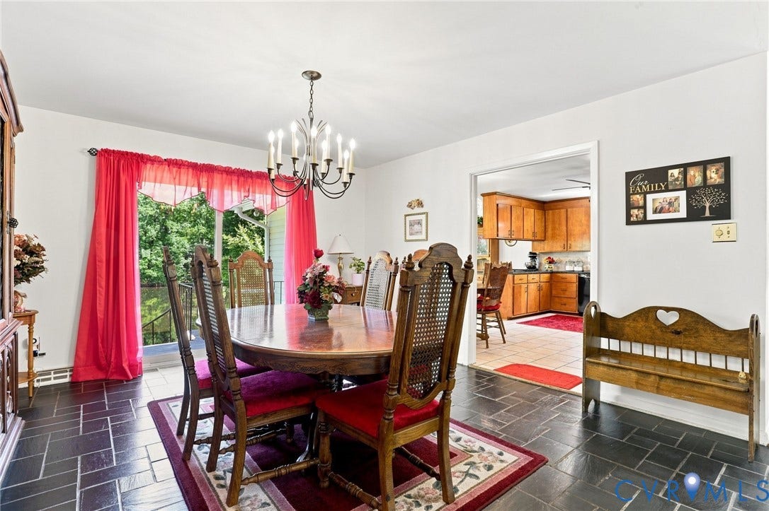 4512 Forrestal Road, Chester, VA 23831 Dining area with dark tile flooring, a multi-arm chandelier, and a sliding glass door