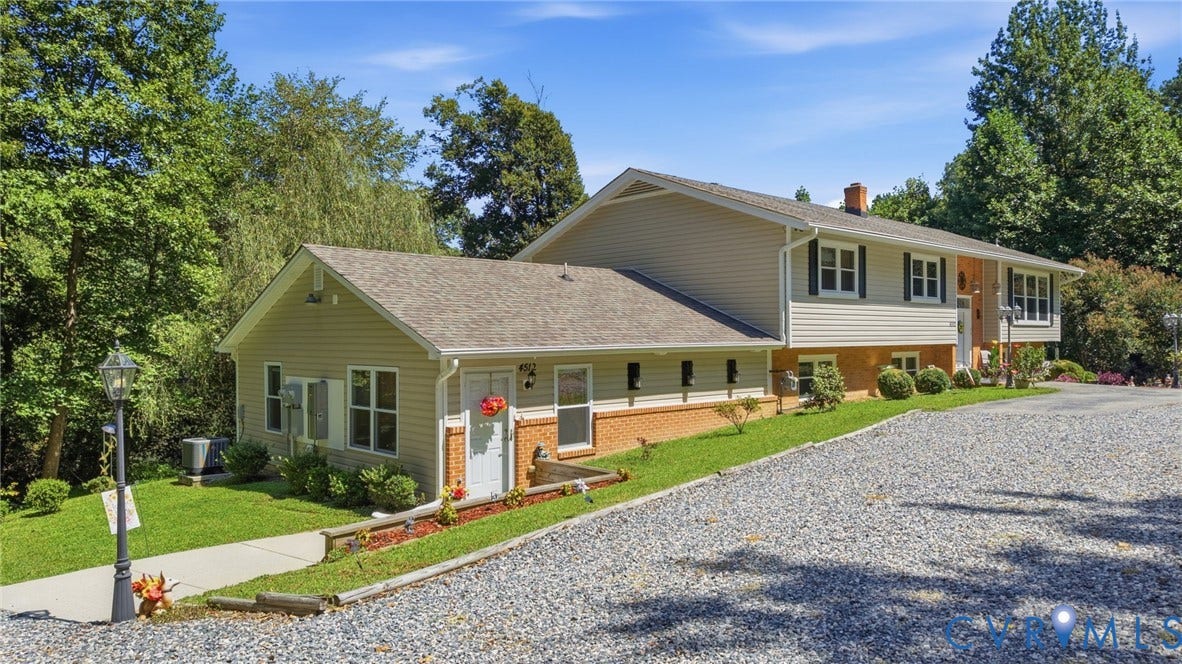 4512 Forrestal Road, Chester, VA 23831 Split-level residence with a brick and vinyl exterior, featuring a gabled roofline and multiple windows that flood the interior with natural light