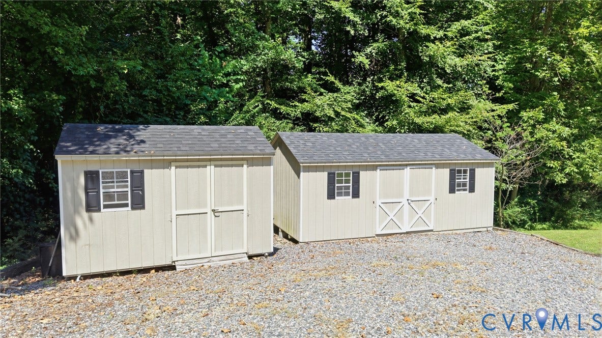 4512 Forrestal Road, Chester, VA 23831 Versatile storage structures featuring classic board-and-batten siding, multiple windows with functional shutters, and composition shingle roofing