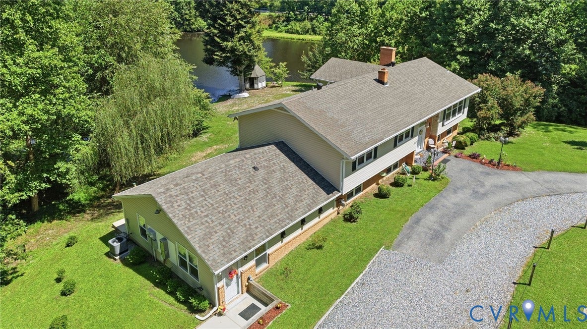 4512 Forrestal Road, Chester, VA 23831 Expansive property featuring a paved and gravel driveway, mature trees, and a visible body of water