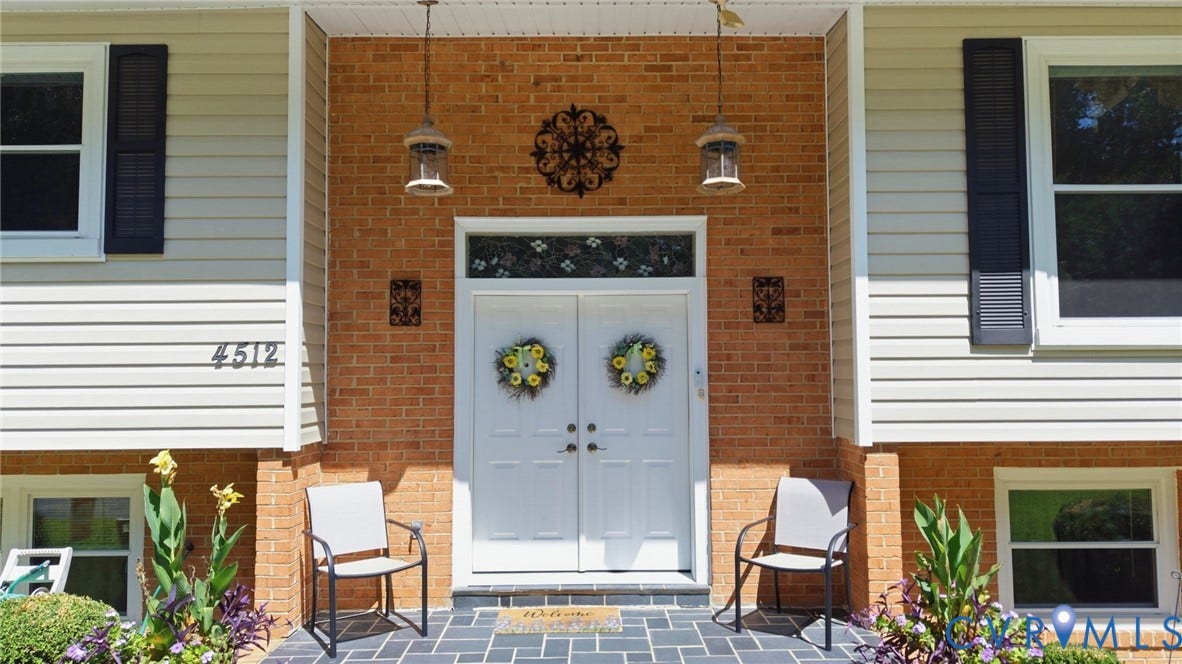 4512 Forrestal Road, Chester, VA 23831 Welcoming brick facade anchors this home, featuring a centered double-door entry with transom window and decorative wreaths