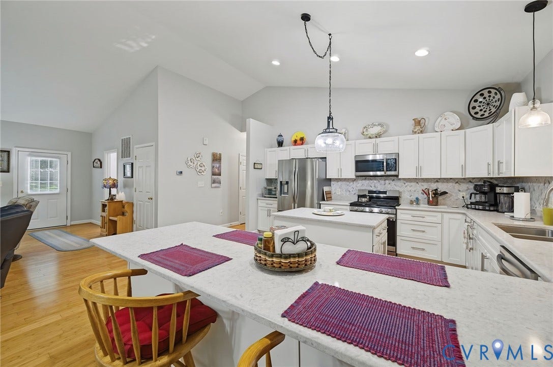 1577 Moody Town Road, Bumpass, VA 23024 Vaulted ceilings, wood-finish flooring, white cabinetry, integrated stainless steel appliances, and quartz countertops