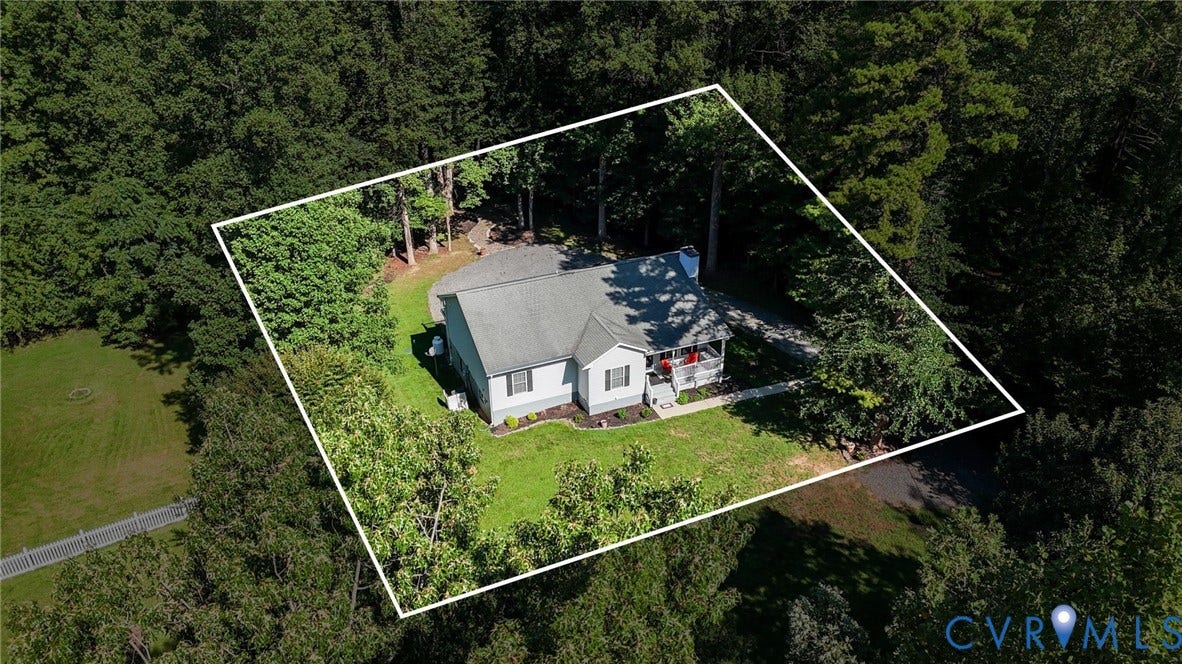 1577 Moody Town Road, Bumpass, VA 23024 Single-story residence surrounded by mature trees, featuring a light-colored exterior and a prominent front porch