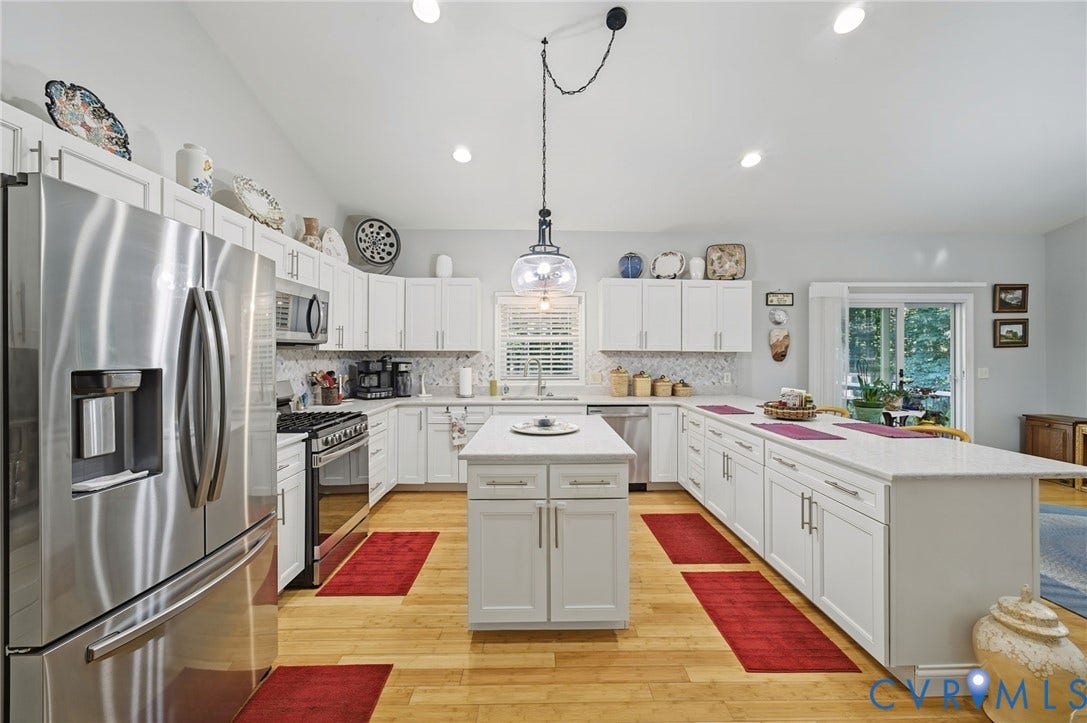 1577 Moody Town Road, Bumpass, VA 23024 Spacious kitchen featuring white cabinetry, light countertops, wood-finish flooring, stainless steel appliances, and a central island