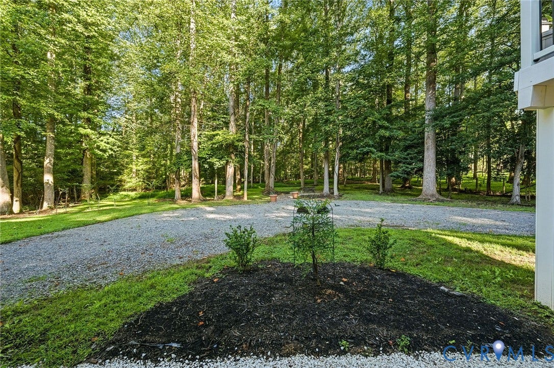 1577 Moody Town Road, Bumpass, VA 23024 Gravel driveway bordered by mature trees and landscaped planting beds