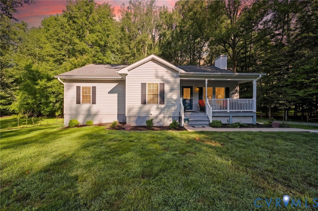 1577 Moody Town Road, Bumpass, VA 23024 Light-colored siding exterior with dark window shutters, covered front porch, white porch railings, and a prominent chimney feature