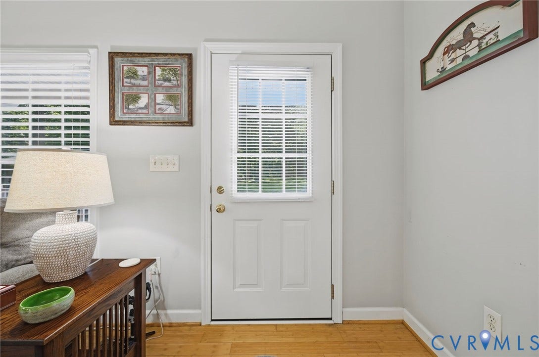 1577 Moody Town Road, Bumpass, VA 23024 White paneled door with glass insert, wood-finish flooring, and white window blinds
