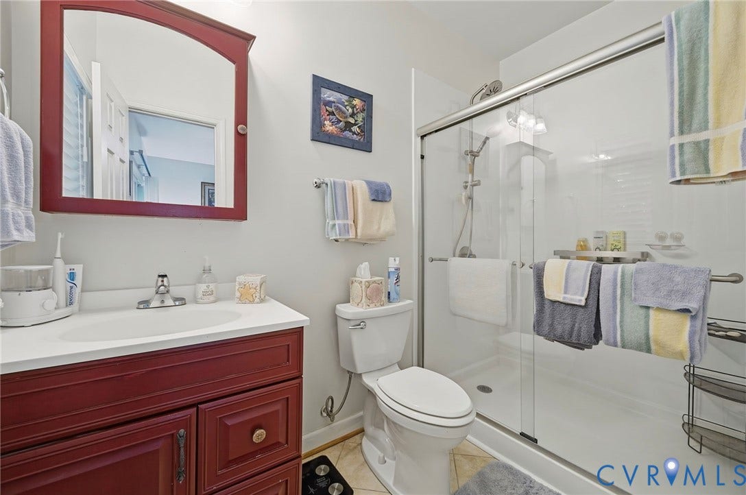1577 Moody Town Road, Bumpass, VA 23024 Red wood-finish vanity with a white countertop and integrated sink