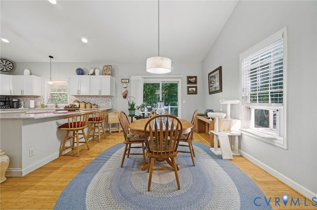 1577 Moody Town Road, Bumpass, VA 23024 Vaulted ceilings, wood-finish flooring, white cabinetry, a sliding glass door, and an overhead light fixture