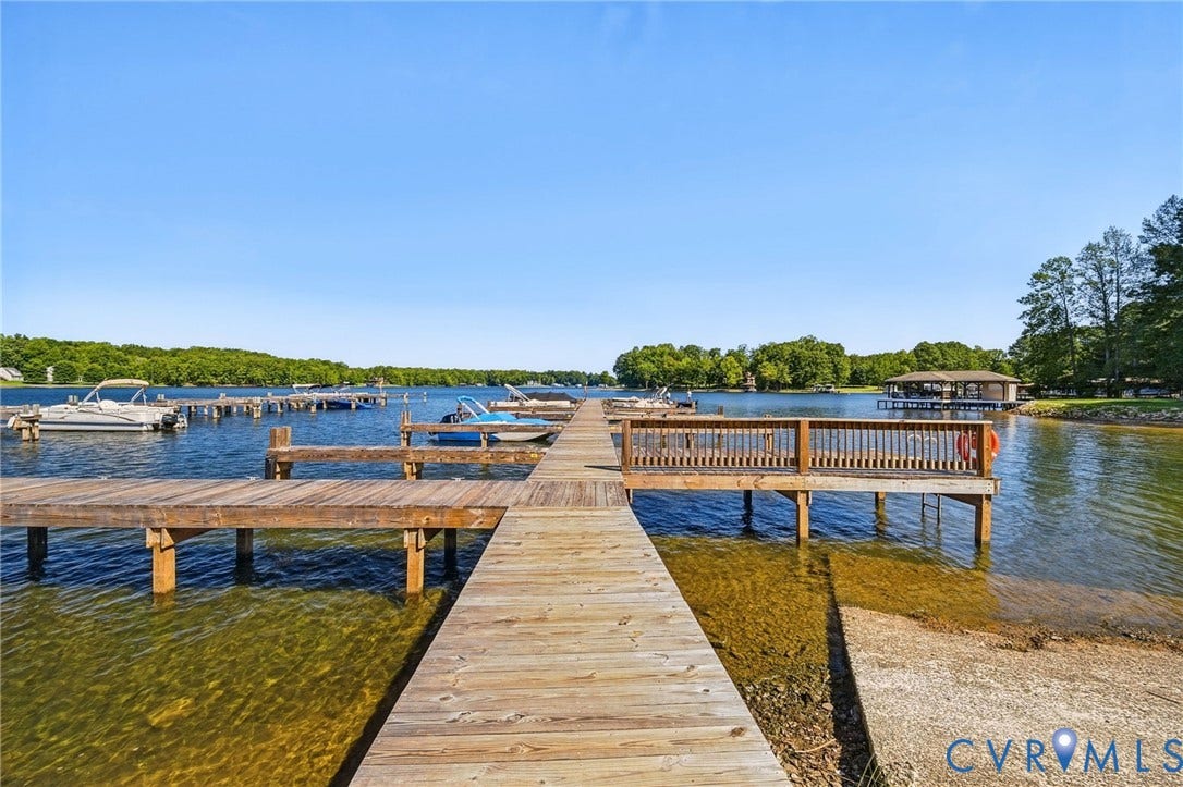 1577 Moody Town Road, Bumpass, VA 23024 Expansive lakefront setting featuring a wooden dock and a boat ramp