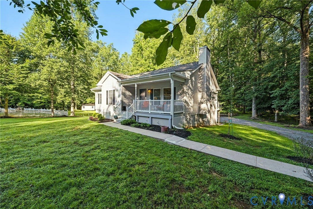 1577 Moody Town Road, Bumpass, VA 23024 Property exterior featuring a covered porch, vinyl siding, a stone chimney, and a gravel driveway