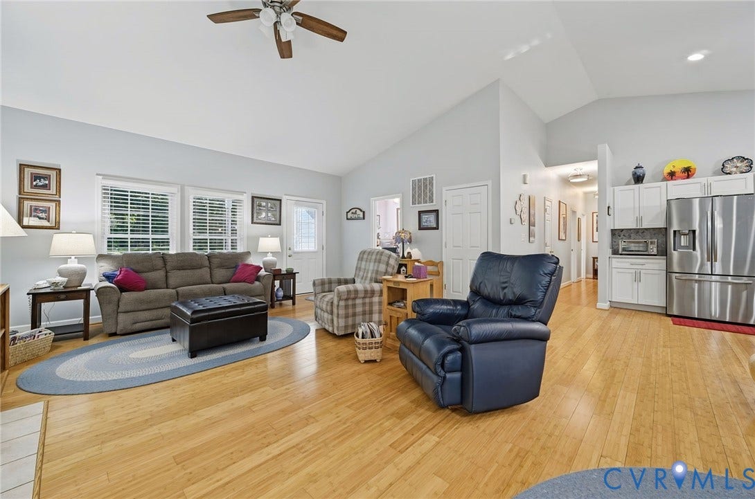 1577 Moody Town Road, Bumpass, VA 23024 Vaulted ceiling, wood-finish flooring, white window blinds, ceiling fan, and white kitchen cabinetry
