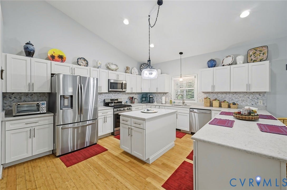 1577 Moody Town Road, Bumpass, VA 23024 Kitchen featuring light wood-finish flooring, white cabinetry, stainless steel appliances, a center island with countertop, and a patterned backsplash