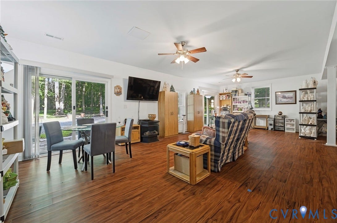 1577 Moody Town Road, Bumpass, VA 23024 Wood-finish flooring, white walls, multiple ceiling fans, and sliding glass doors