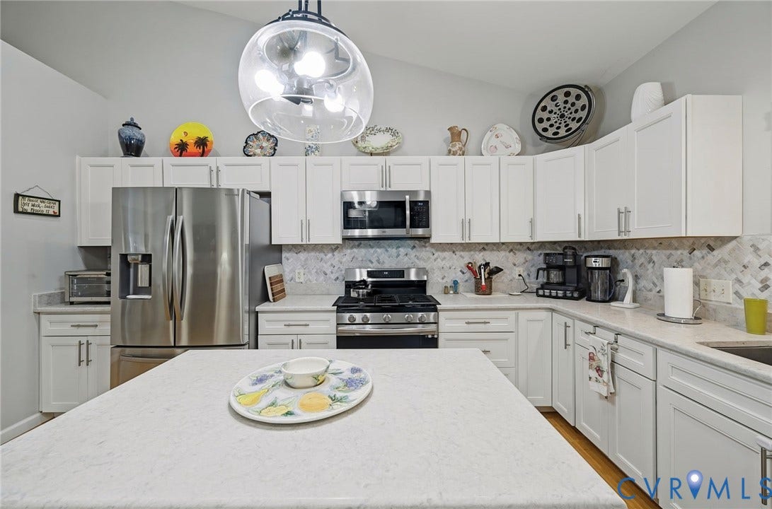 1577 Moody Town Road, Bumpass, VA 23024 Kitchen featuring white cabinetry, stainless steel appliances, light-toned countertops, a mosaic tile backsplash, and a vaulted ceiling