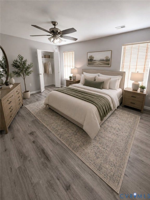 Primary bedroom with modern wood-toned LVP in the bedroom and two large closets.  Features ensuite with double vanities and garden tub.